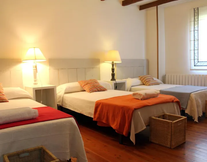Interior · dormitorio con tres camas.