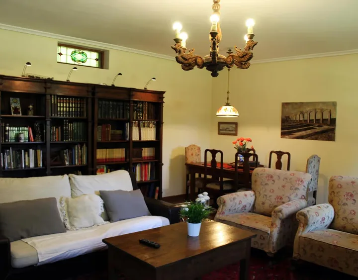 Interior · gran salón con biblioteca y chimenea.