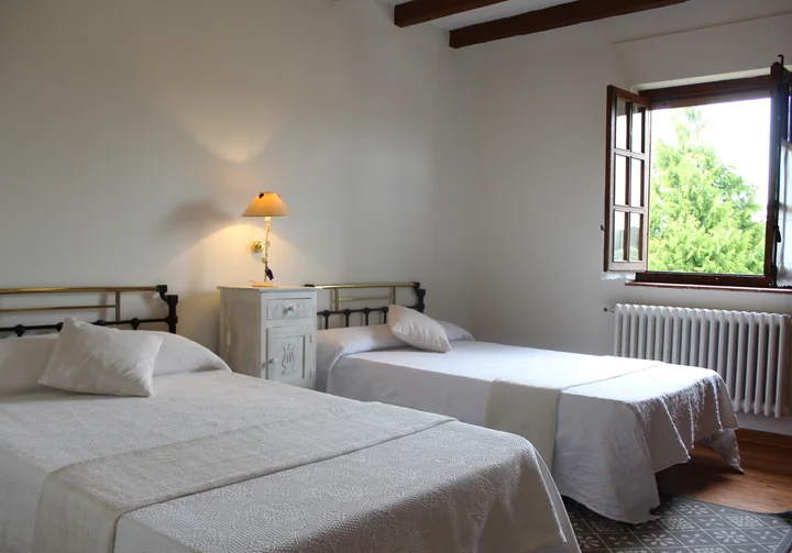 Interior · dormitorio de dos camas con vistas al jardín.
