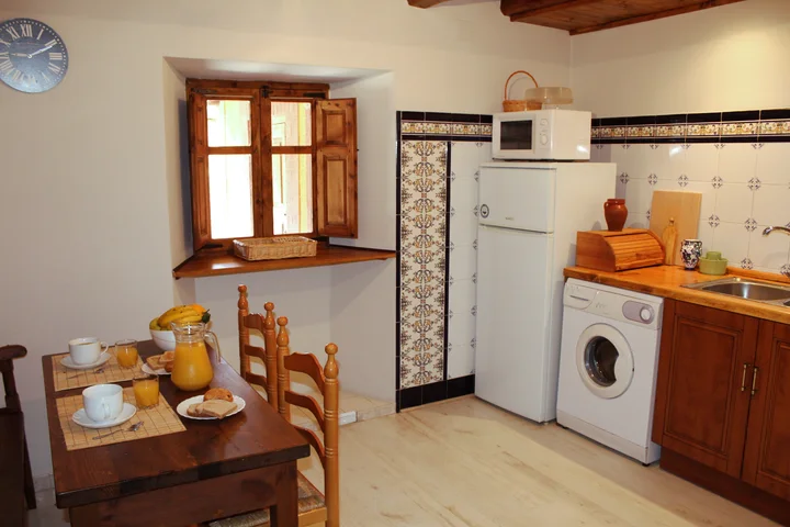 Interior · cocina equipada con mesa junto a la ventana.