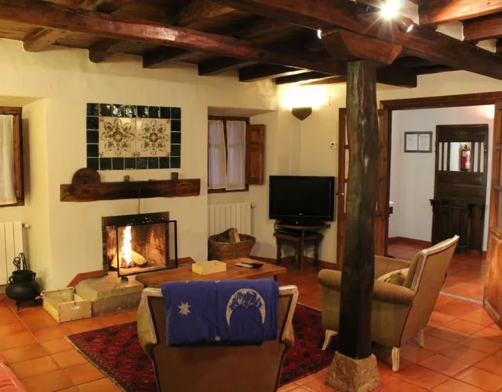 Interior · salón de 80 m² con chimenea y vigas.
